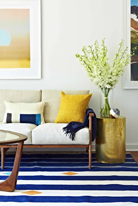 a living room with a couch and a vase with flowers